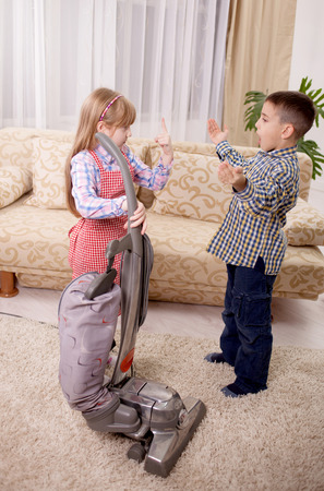 little girl cleaning the room - using vacuum cleaneの写真素材