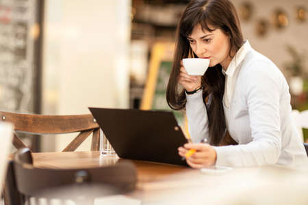 businesswoman sitting at a cafe and workingの写真素材
