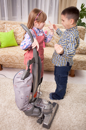 little girl cleaning the room - using vacuum cleaneの写真素材