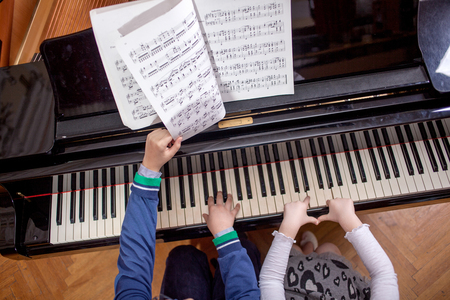 Brother And Sister Playing Pianoの写真素材