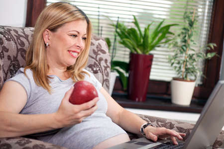 pregnant woman at home relaxing with musicの写真素材