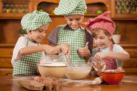 beautiful caucasian child making a cake, smiling happilyの写真素材
