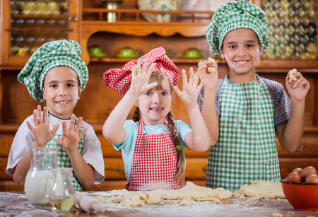 beautiful caucasian child making a cake, smiling happily,の写真素材