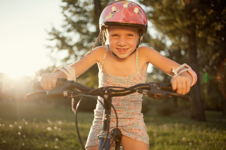 little school-girl rides  bike in the parkの写真素材