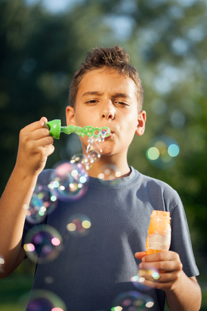 Cute boy blowing a soap bubblesの写真素材