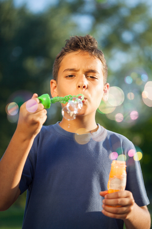 Cute boy blowing a soap bubblesの写真素材