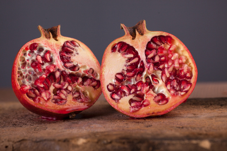 Juicy pomegranates on stone plateの写真素材