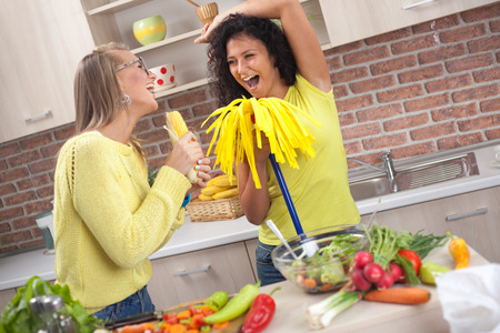 Young housewife fool around in the kitchen and make a vegetarian mealの写真素材
