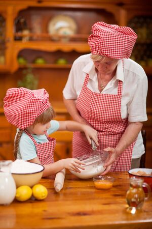 Grandmother and granddaughter baking cookiesの写真素材
