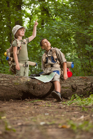 boys go hiking with backpacks on forest road bright sunny dayの写真素材