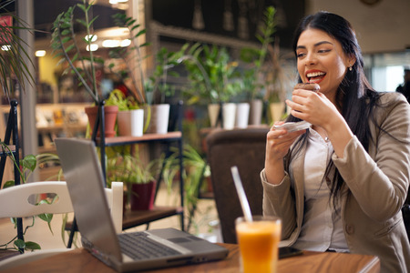 Young hipster girl enjoys cake, sitting in cafe resting and relaxesの写真素材