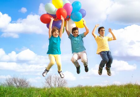 Happy childs playing with colorful toy balloons outdoorsの写真素材
