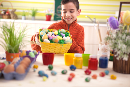 Happy boy holding colorfull Easter basketの写真素材