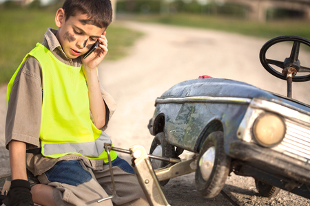 help on the road, a young boy with his toy carの写真素材