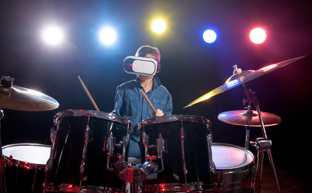 young boy playing drums  using viewer for virtual realityの写真素材