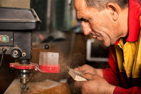 carpenter in the workshop, drill in handの写真素材