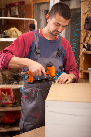 Man builds furniture in the carpentry shop.の写真素材