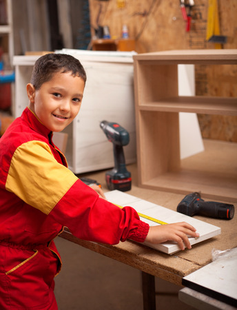 young boy learns the craft of carpentersの写真素材