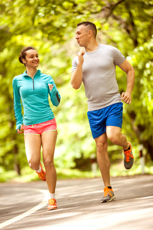 Young couple jogging at the woodsの写真素材