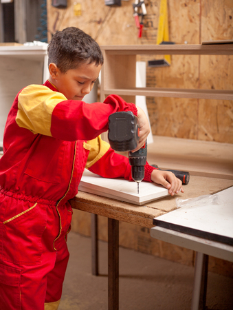 boy learning wood carving. young carpenter working in a workshopの写真素材