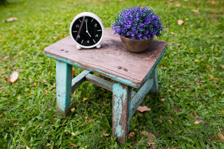 White clock on the old green wooden chair