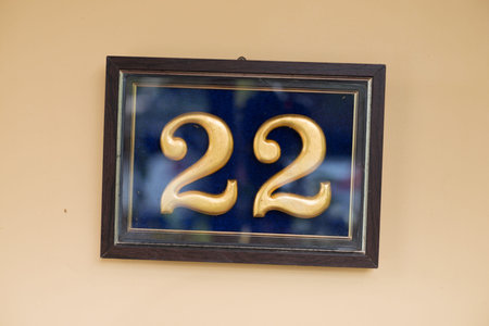 gold painted wooden number twenty-two in wooden frame
