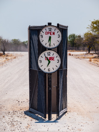 Campsite gate with marked opening and closing time (Halali, Etosha National Park, Namibia)の写真素材