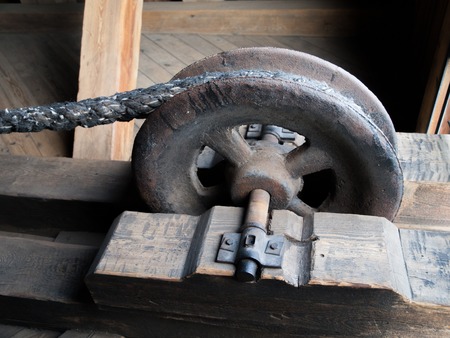 Detailed view of a rusty drag metal wheel as a part of pulleyの写真素材
