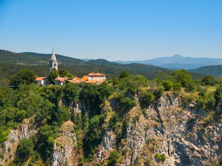 View of deep gorge of Reka River and village with rural church ,Skocjan Caves, Sloveniaの写真素材