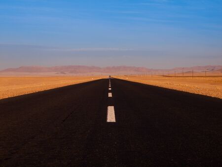 Endless desert asphalt road on hot sunny dayの写真素材