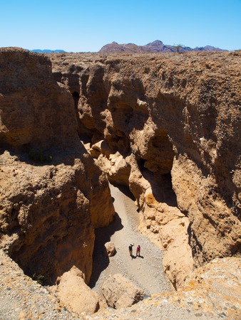 Two people on the bottom of Sesriem Canyon near Sossusvlei shaped by Tsauchab River, Namib Desert, Namibiaの写真素材