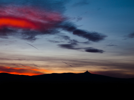 Dramatic sunset sky with colorful clouds and silhouette of Jested ridge, Liberecの写真素材