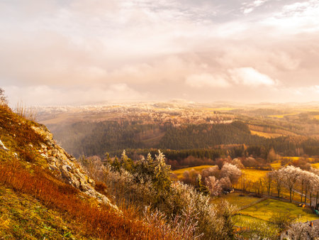 Aerial view of colorful autumn first frost landscape with dramatic cloudy sky. Grass and trees with...