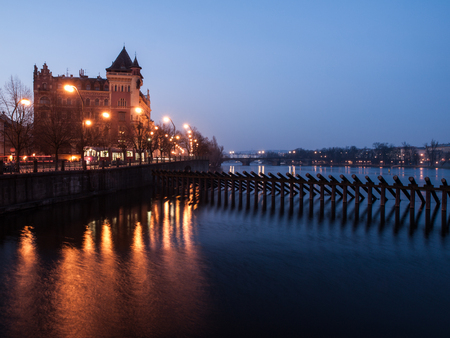 Early morning in Prague Old Town. Warm street lamps on Smetana Embankment reflected in cold Vltava River. Prague, capital city of Czech Republic, Europe. UNESCO World Heritage Site.の写真素材