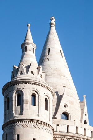 Typical light stone rounded fairy tale towers of Fisherman's Bastion, aka Halaszbastya, on a terrace in neo-Gothic and neo-Romanesque architectural style. Lookout turrets are situated on a Buda bank side of Danube River in Budapest, capital city of Hungarの写真素材