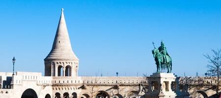 Mounted statue of Saint Stephen I, aka Szent Istvan kiraly - the first king of Hungary at typical white rounded tower of Fishermans Bastion in Buda Castle in Budapest, Hungary, Europe. Sunny day shot with blue sky on the background.の写真素材