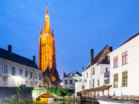 Church of Our Lady and bridge over water canal by night, Bruges, Belgium.の写真素材
