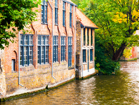 Old brick houses along water canals in Bruges, Belgium.の写真素材