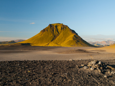 Green hills and black rocky ground of Icelandic Highlands along Laugavegur hiking trail, Iceland. Sunny summer day shot.の写真素材