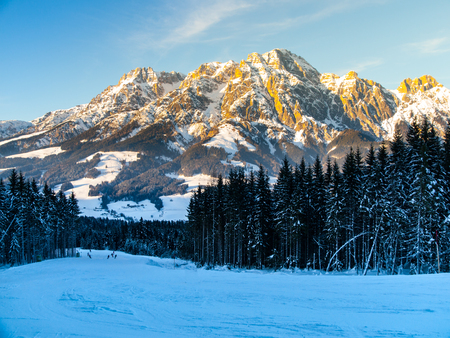 Downhill slope in Saalbach Hinterglemm Leogang winter resort, Tirol, Austria, Europe. Sunny morning with clear sky and illuminated mountain massive on the background.の写真素材