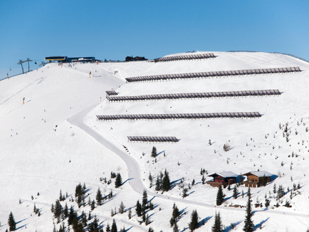 Avalanche protection barriers on steep slope in winter ski resort. Sunny winter day in mountains, Alps, Austria.の写真素材