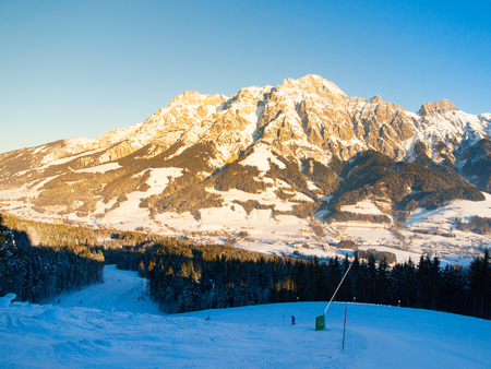 Downhill slope in Saalbach Hinterglemm Leogang winter resort, Tirol, Austria, Europe. Sunny morning with clear sky and illuminated mountain massive on the background.の写真素材