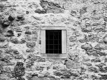 Old prison jail window with rusty metal bars. Vintage style image. Black and white image.の写真素材