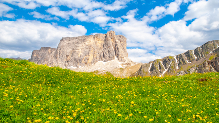 Landscape of Dolomites with green meadows, blue sky, white clouds and rocky mountains.の写真素材