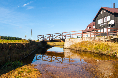 Bridge over Jizerka creek at old wooden hut - Old Sawmill, czech: Stara pila, on sunny summer day. Jizerka village, Jizera Mountains, Czech Republic.の写真素材