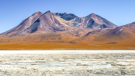 Frozen lagoon of altiplano with mountain peak on background. Bolivia, South America.の写真素材