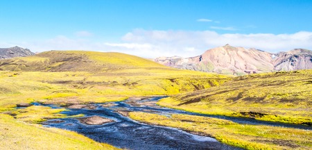 Green hilly landscape of Iceland Highlands with glacier river around Laugavegur hiking trail on sunny day, Iceland.の写真素材