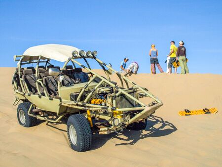 ICA, PERU - JULY 6, 2010: Sand dune buggy parked on a dune and group of people having fun. Ica, Peru.のeditorial素材