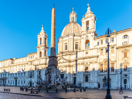 Four Rivers Fountain, Italian Fontana dei Quattro Fiumi, with obelisk and St Agnes Church on background. Piazza Navona square, Rome, Italy.の写真素材