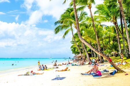 MAURITIUS - NOVEMBER 03, 2019: Sunny holiday in tropical paradise. Blue sea and sky, white sand beach and green palm trees.のeditorial素材